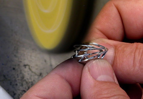 Jeweler polishing a platinum ring at a polishing machine. 