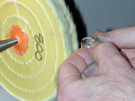 A jeweler preparing to polish a platinum ring using the yellow-treated wheel labeled “800”