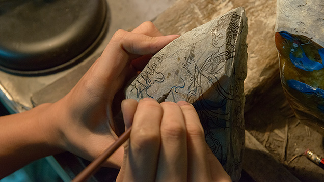 艺术家将设计图绘制在硬玉原石上