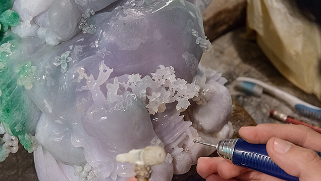 艺术家在用小金属钻头雕刻硬玉