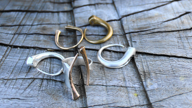 耳环展示在木头底座上，戒指陈列在前面。