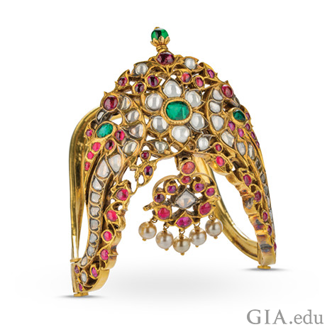 华丽的黄金臂环上刻有文字，还镶嵌有钻石、红宝石、祖母绿和珍珠。