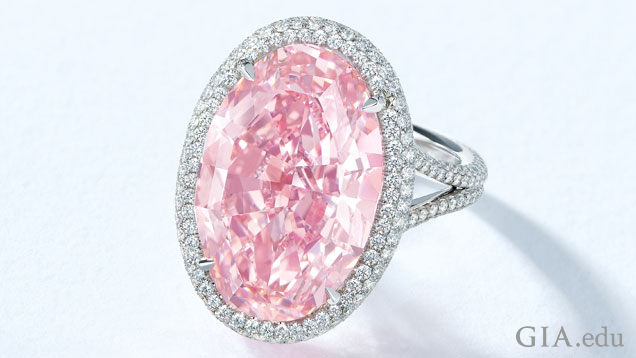 一颗 14.93 克拉的椭圆形粉红色钻石镶嵌在一枚戒指上，四周环绕着一圈无色钻石。