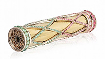 Lattice-patterned gems encase an 18K gold kaleidoscope. 