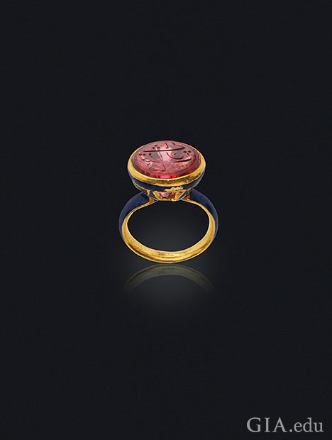 一枚顶部镶嵌尖晶石雕件的珐琅印章戒指。