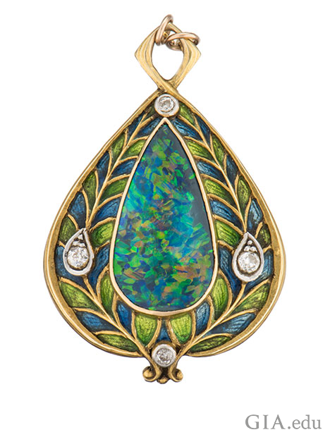 ペアシェイプのブラックオパールのカボションが、ヨーロッピアンカットのダイヤモンドと青と緑色のエナメルによって飾り立てられ、14Kゴールドにセットされている。