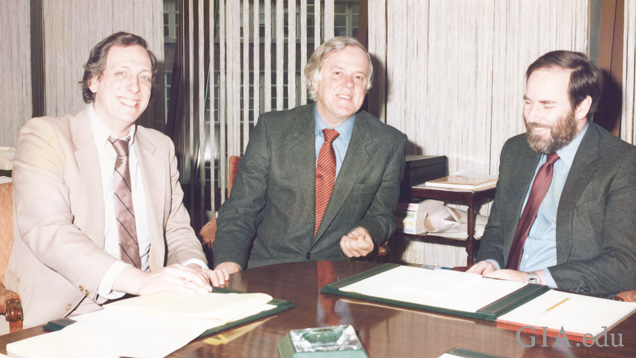 会議室のテーブルを囲む3人の男性。