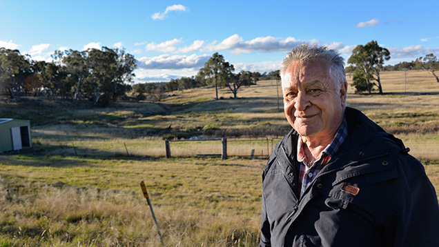 古いサファイア採鉱場の前に立つ男性