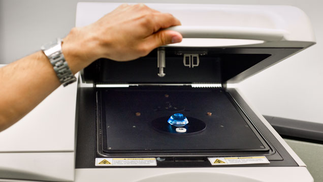 一颗大型刻面黄色锂辉石被放置在分光光度计的样品室内，以记录其可见光光谱。