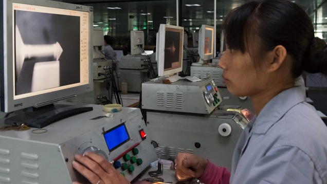 ラウンドブリリアントカットのダイヤモンドは、ダイヤモンド砥粒と流水でコーティングされたスピニングホイールに対してブルーティングされます。