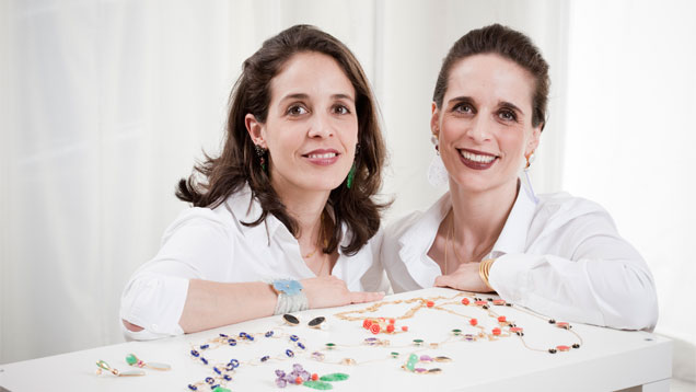 Sisters and Bahina Jewels owners Noëlle Vieillard-Jordi, left, and Annick Jordi, right, with a few of their designs. “Bahina” is a Hindi term meaning “two sisters.” Photo by Guy Perrenoud, courtesy Bahina Jewels