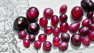 鉛ガラス充填処理をした34個のスタールビーは、ピンクから赤、または黒に近い色調です。 写真の石は1カラットから20カラットほどの大きさです。