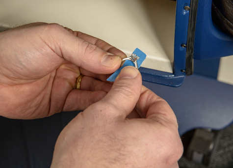 Jeweler wrapping a platinum solitaire using masking tape