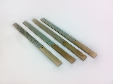 Four abrasive sticks containing micro-finishing film in four different abrasive grits.