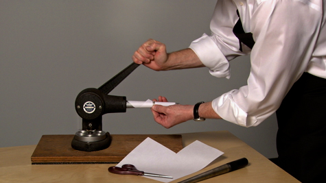 Jeweler using a ring stretcher, wrapped with paper, to stretch a band