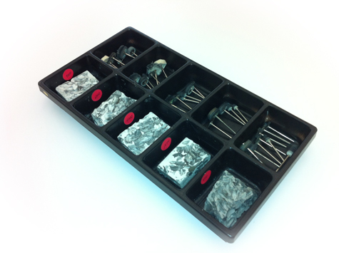 Tray containing five compartments of platinum polishing compound, and five additional compartments with various wheels and brushes