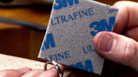 Abrasive sponge being used on a platinum ring band