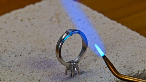 Torch with single cone tip being used to solder a platinum ring setting