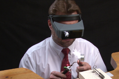 Jeweler at the bench using a torch to size a ring