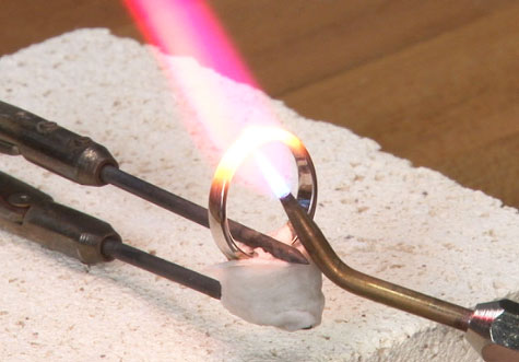 使用有碳化钨或铂金头部的镊子夹住铂金戒指。 在镊子和戒指之间放几层纸巾，防止出现划痕。 为主石涂覆防火溶液， 裹上湿纸巾，使其免受高温影响。 使用 1700 铂金无缝修复焊料。 预热戒指内环，保持焊炬位于接合处下方。 调整焊炬的位置，使加热区域位于火焰内焰之外，然后将焊炬移到接合处上方，直接加热接合处与焊料。焊料熔化并流入接合处后，立即移开焊炬。 由于将湿纸巾和硬质合金镊子用作散热器，吸走了焊接接合处的热量，火焰一定非常灼热。