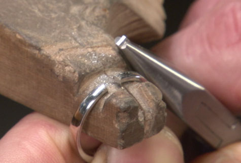 特写镜头显示一枚移除了一部分的铂金戒圈，以备缩小尺寸