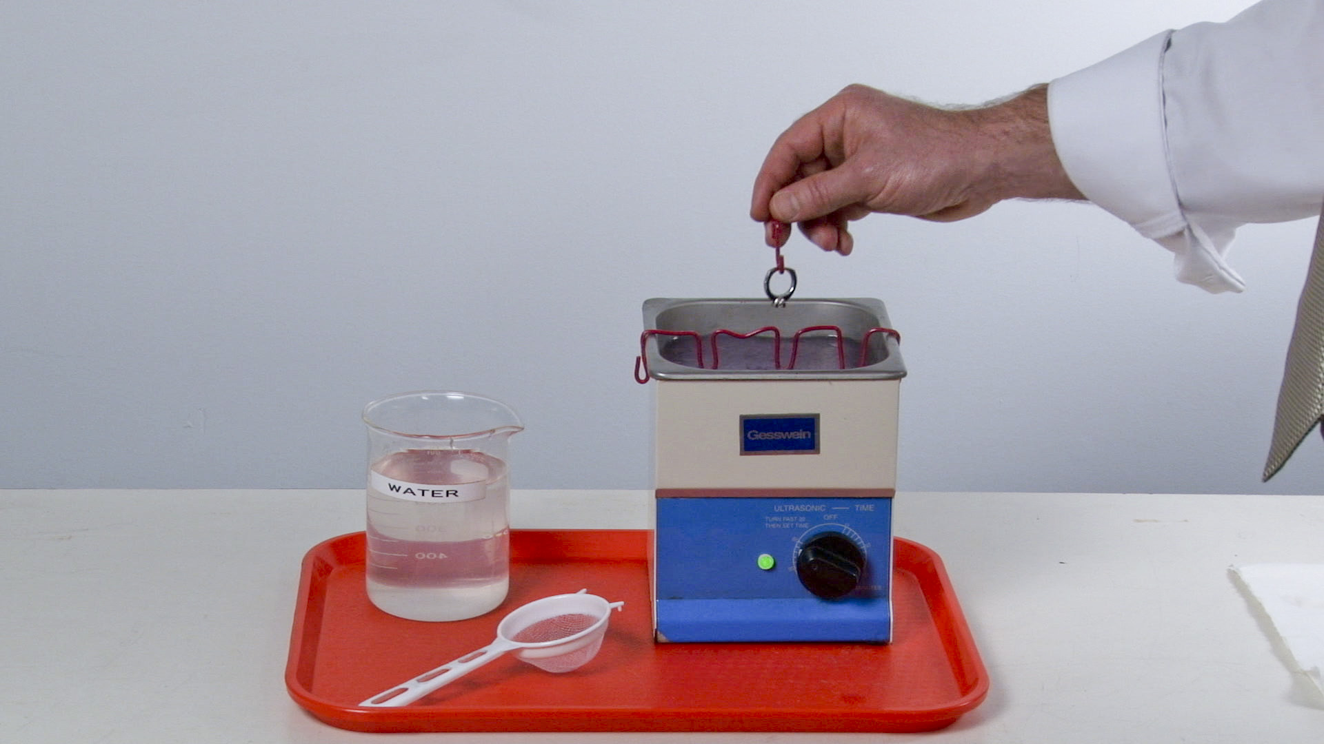 Close-up view of a jeweler cleaning a platinum solitaire in preparation for prefinishing