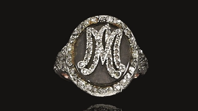 A small oval shape ring holds a lock of Marie Antoinette’s hair. Her initials are set in small rose cut diamonds on the top of the oval.