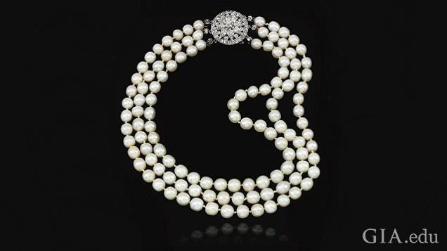 Three strands of pearls with a diamond clasp.