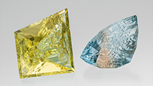 Figure 1. This 109.68 ct heliodor and 80.62 ct bicolor topaz are from the Volyn deposit in Ukraine. They are cut to leave natural etch faces on the pavilion/culet, while the crown and table are faceted. Photo by Robert Weldon; courtesy of Nomad&rsquo;s.