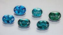 Figure 1. Suite of faceted nickel-diffused spinel (0.67&ndash;1.01 ct) showing a range of color from blue to bluish green. Photo by Aaron Palke and Diego Sanchez.