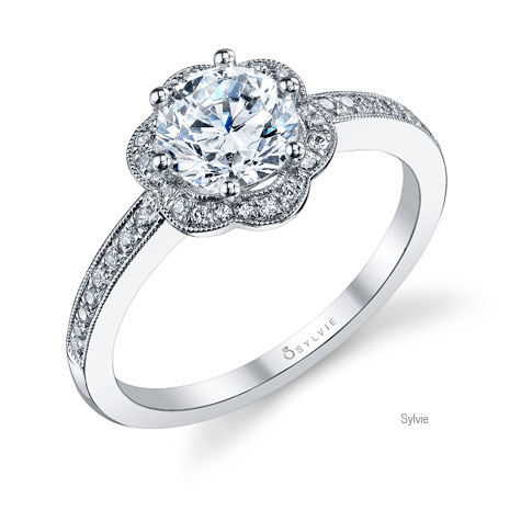 Perspective view of platinum ring designed by Sylvie, featuring a flower-shaped diamond halo surrounding a large center diamond, and diamonds set halfway down the shank.