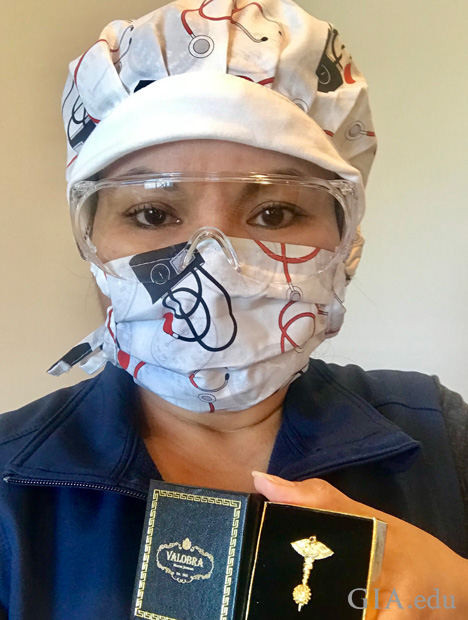 保護ゴーグルとマスクをした看護師が、新型コロナウイルス撲滅ピンが入った箱を持っている。