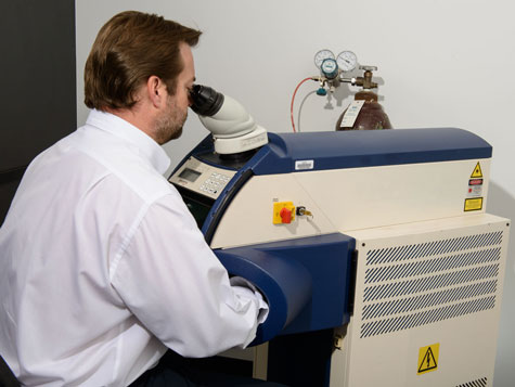 レーザー溶接機に座り、プラチナリングを溶接する専門家