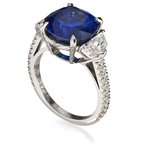 铂金戒指透视图，可以看到一颗蓝宝石主石两侧饰有数颗钻石，镶嵌于戒圈之中。