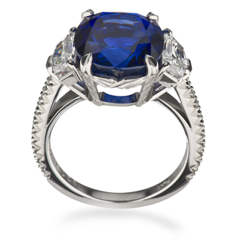 铂金戒指侧视图，可以看到一颗蓝宝石主石两侧饰有数颗钻石，镶嵌于戒圈之中。